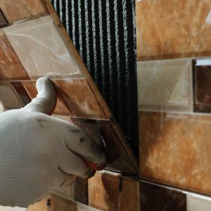 Contractor placing tiles on wall